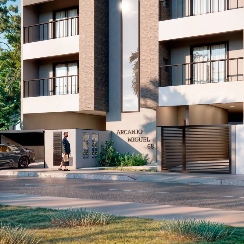 Entrada do Residencial Arcanjo Miguel vista da rua, com portão de garagem e o nome do prédio na fachada